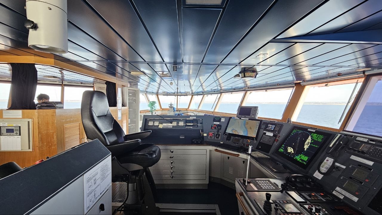 Night bridge watch: radar display and ice-covered water ahead of the bow